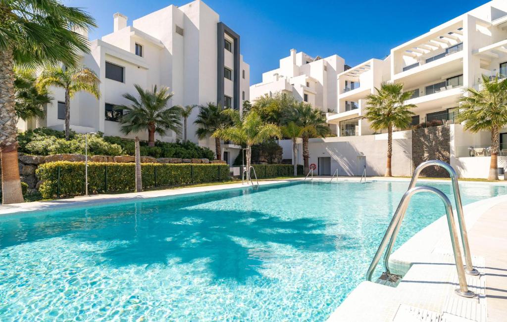 a swimming pool in front of a building with palm trees at 3 Bedroom Amazing Apartment In Estepona in Estepona