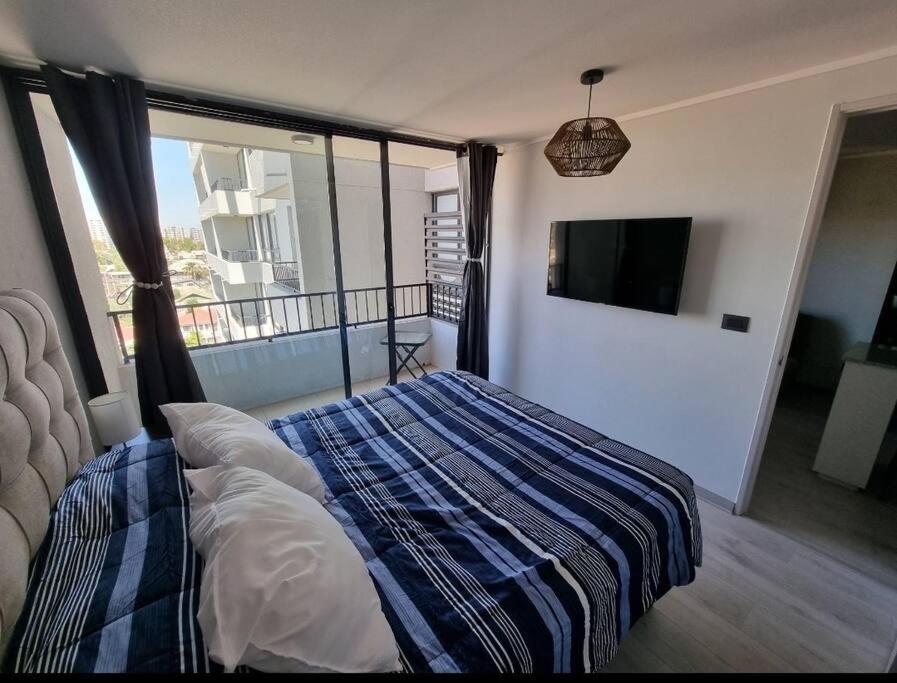 a bedroom with a bed and a flat screen tv at Hermoso y cómodo departamento in Santiago