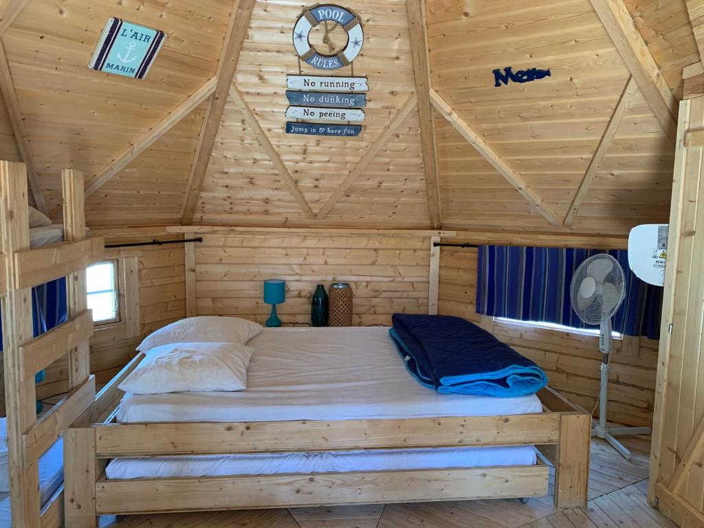 1 dormitorio con 1 cama en una cabaña de madera en Les Hébergements Insolites Catalans, en Saint-André