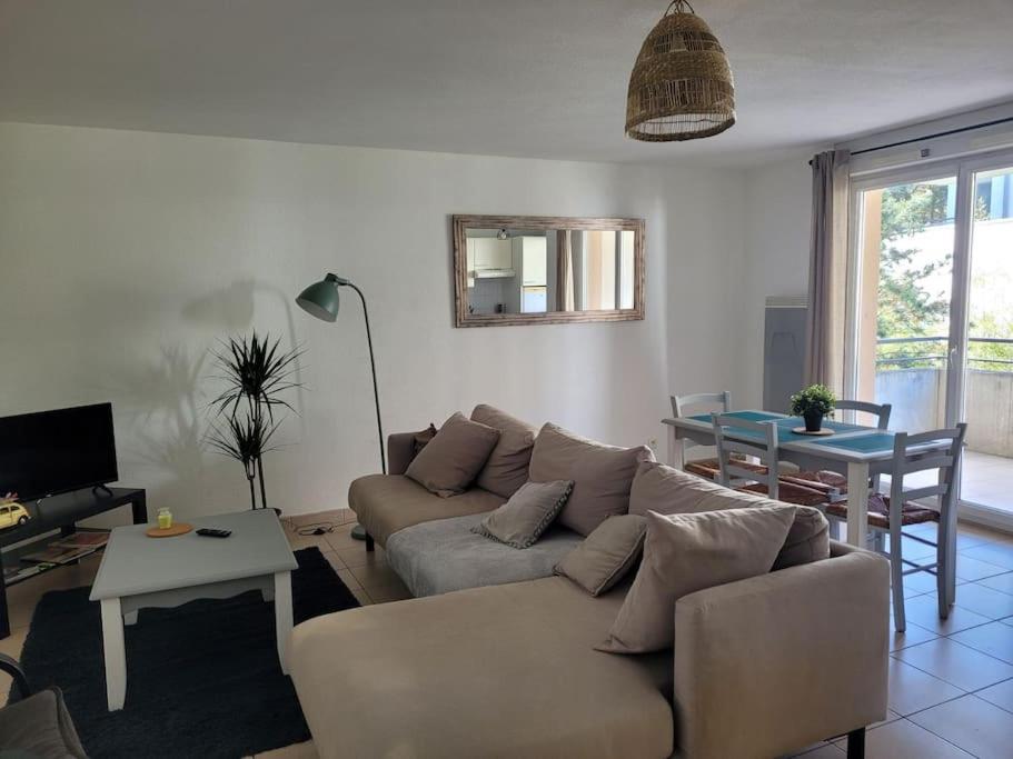 ein Wohnzimmer mit einem Sofa und einem Tisch in der Unterkunft T3 proche bus et tram in Angers