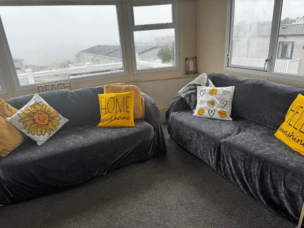 a living room with two couches with pillows on them at Devon Cliffs in Exmouth