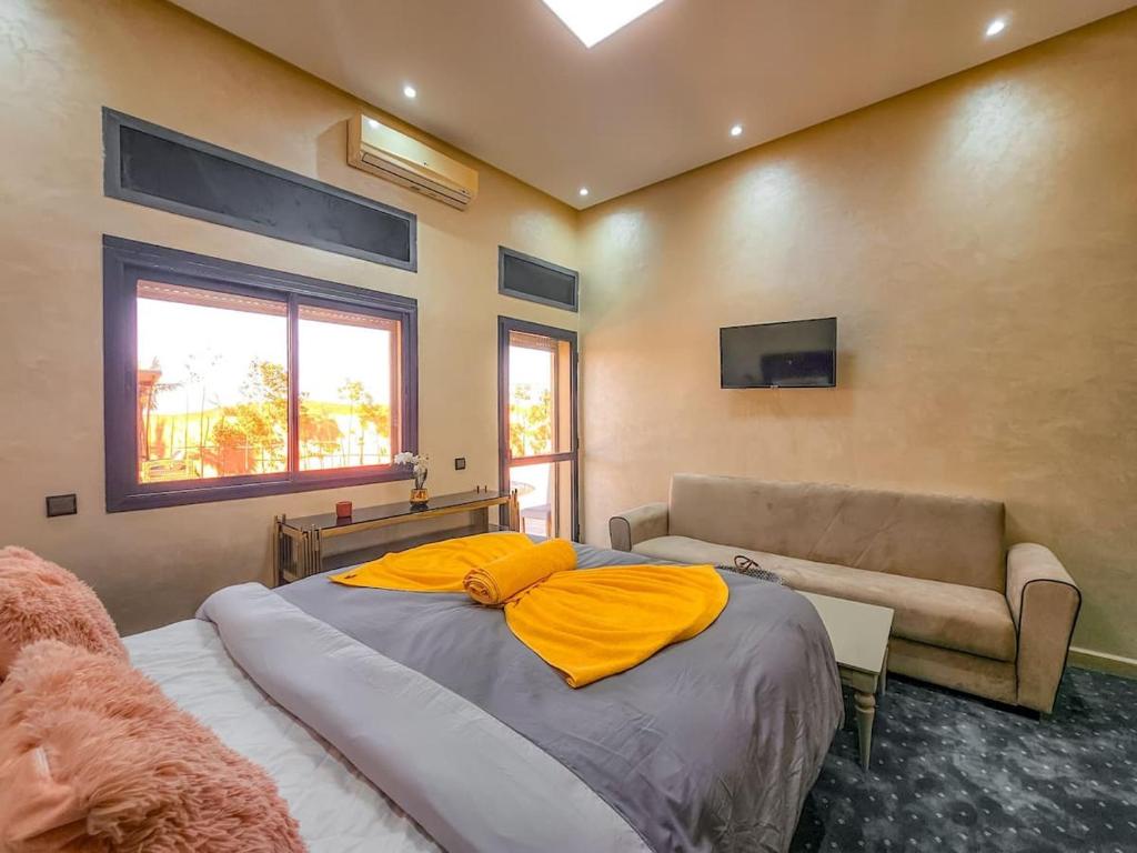 ein Schlafzimmer mit einem großen Bett und einem Sofa in der Unterkunft Maison d'hôtes bon coin in Marrakesch