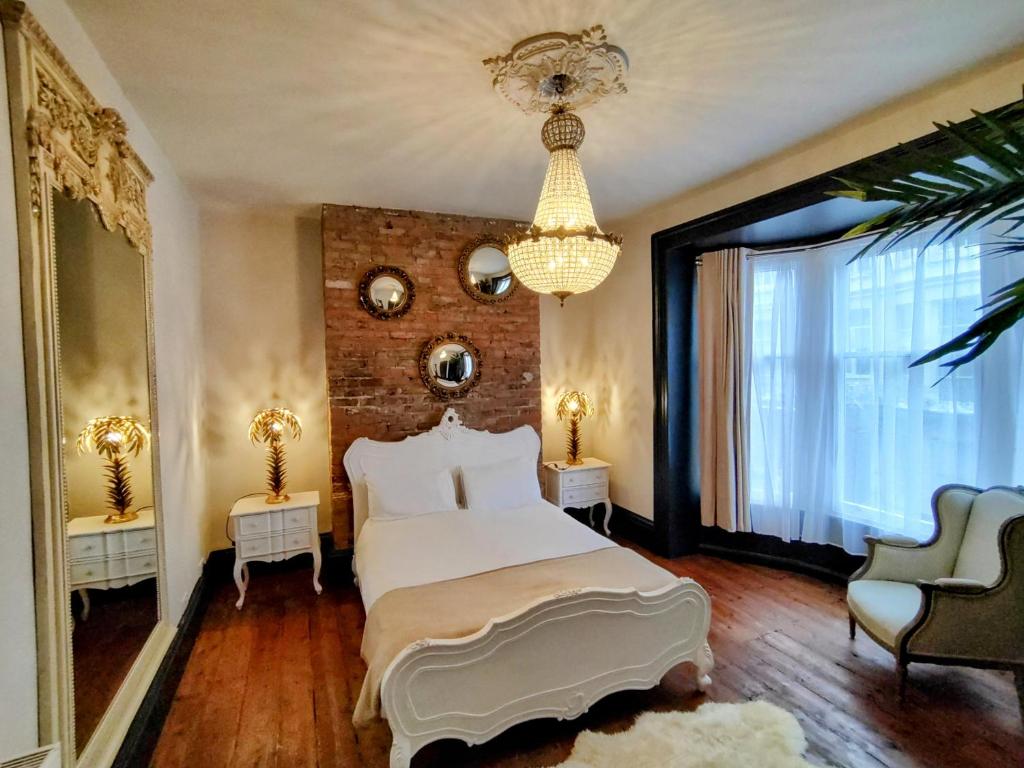 - une chambre avec un lit blanc et un mur en briques dans l'établissement Salt Life Belgravia Apartment, à Brighton et Hove