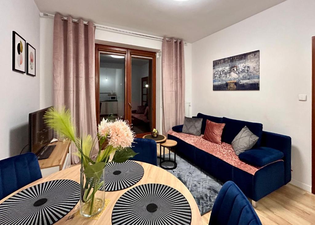 a living room with a blue couch and a table at Apartament Klaudia Polanica-Zdrój in Polanica-Zdrój