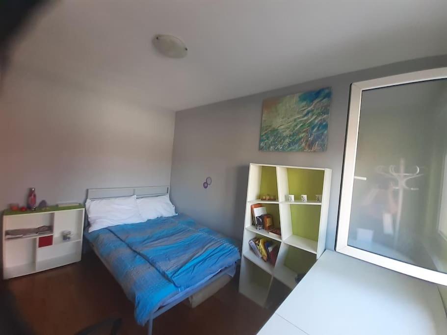 a small bedroom with a bed and a window at Greatly located/parking/balcony/2 bathrooms in Zagreb