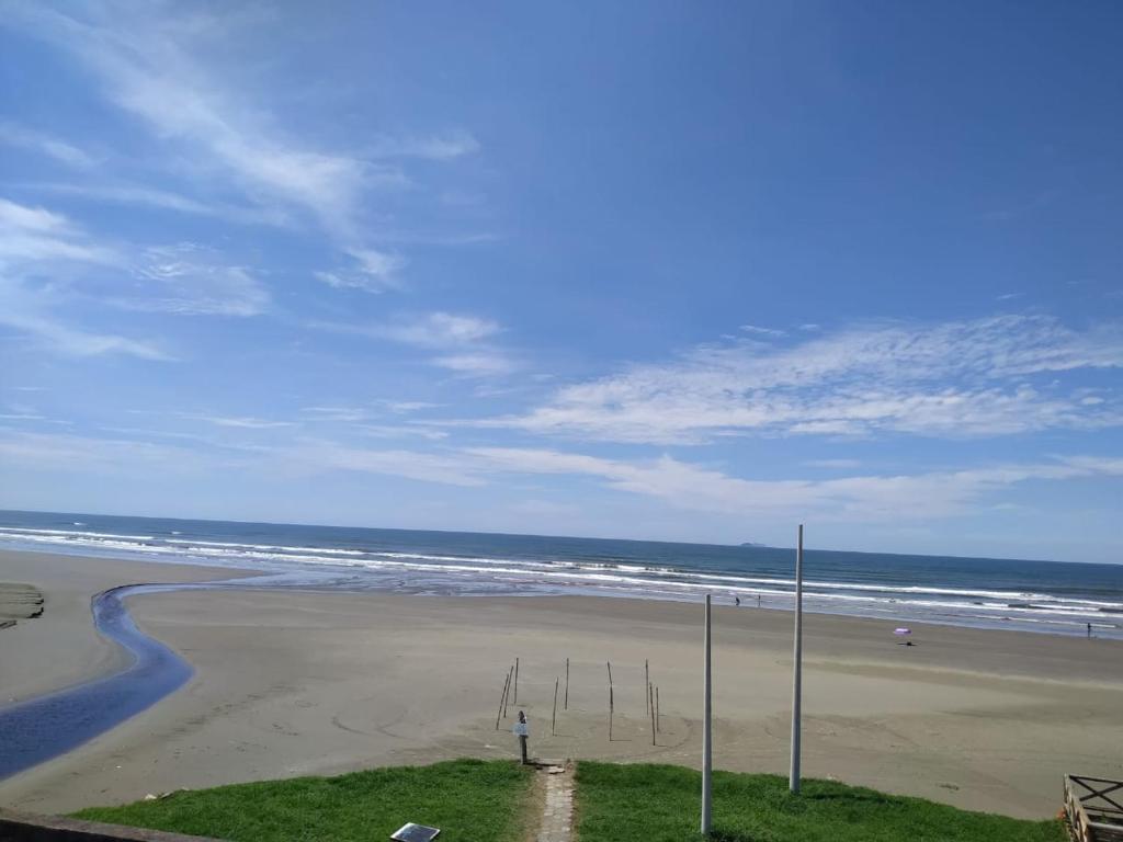 a person standing on a beach with the ocean at Peruíbe Frente ao Mar - Aptos in Peruíbe