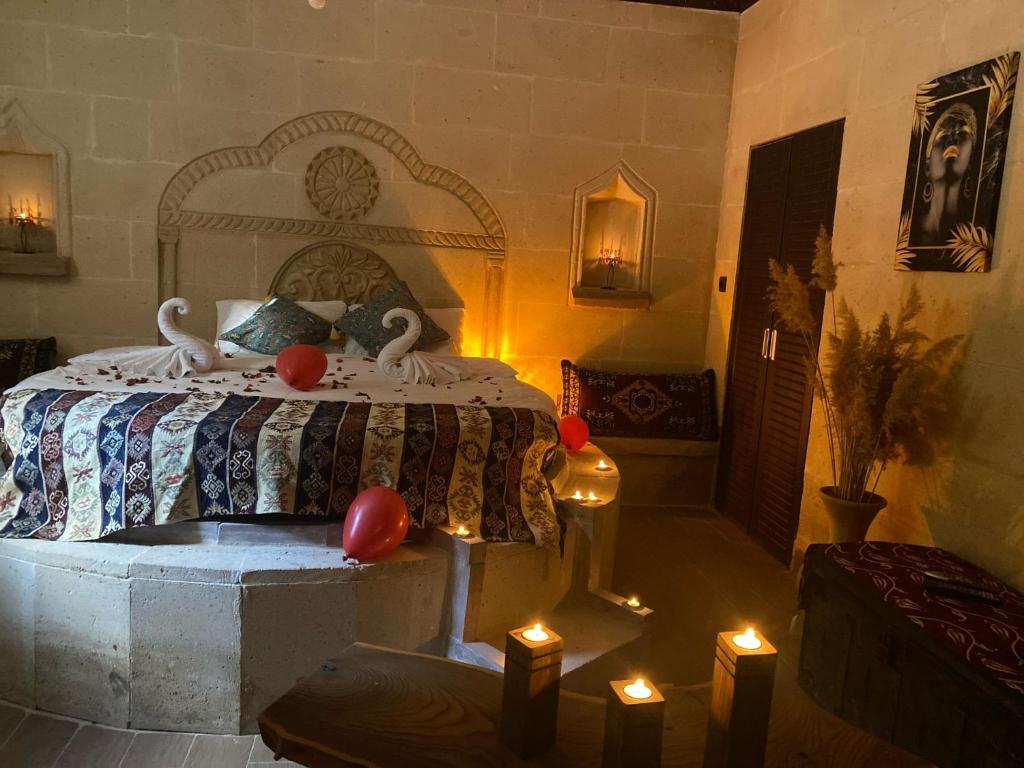 um quarto com uma cama com dois cisnes em Cappadocia Cave Sinasos Villa em Mustafapaşa
