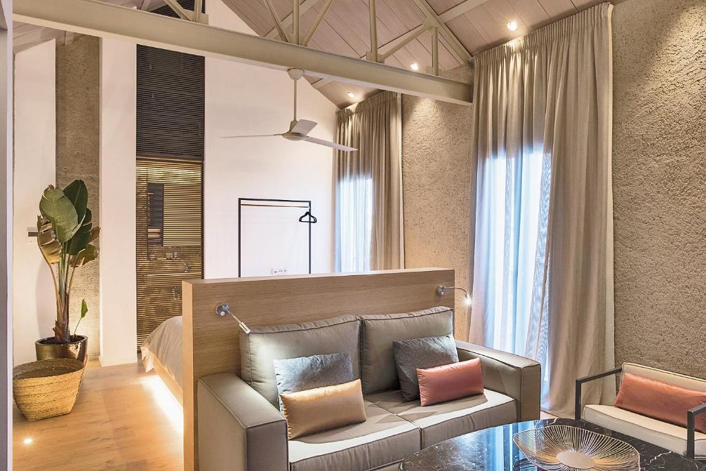 a living room with a couch and a glass table at HomeSuiteHome Córdoba in Córdoba