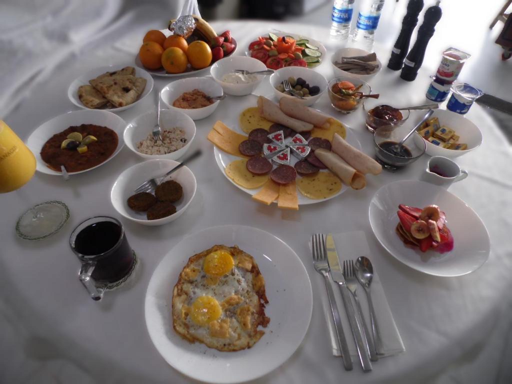 a white table with plates of food on it at Abeer Guest House in Luxor