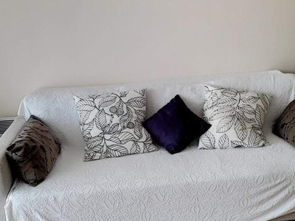 - un canapé blanc avec plusieurs oreillers dans l'établissement Spacieux T2 Cabine à 800m Plages Favière, Loggia Sud-Ouest, Garage Inclus - FR-1-610-7, à Bormes-les-Mimosas