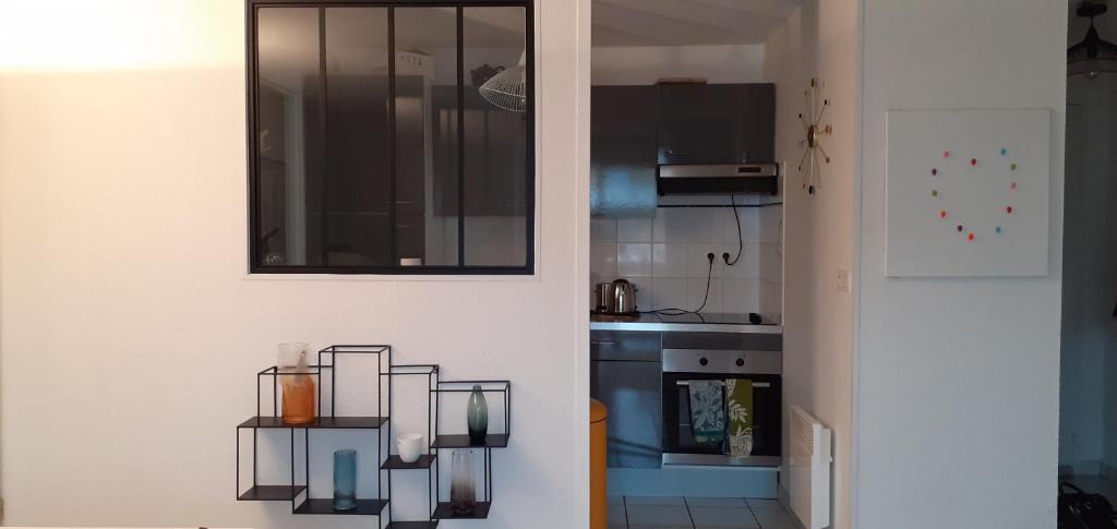 a kitchen with a door with a glass shelf on it at Appartement avec grand balcon sud et parking privé in Saint-Brieuc