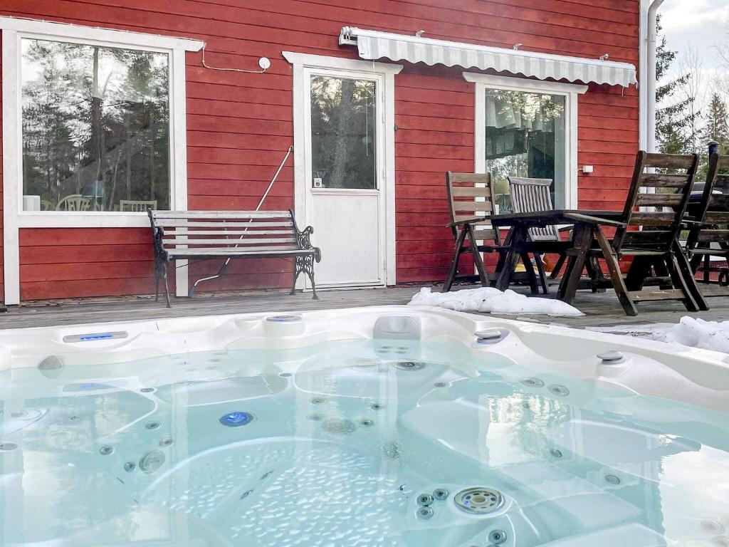 een hot tub buiten een rood huis bij Holiday home VÄDDÖ III in Väddö