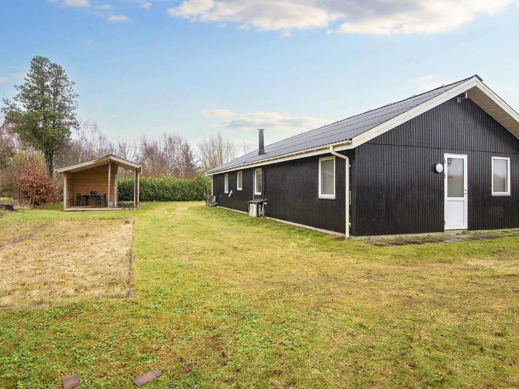 a black house with a yard in front of it at Holiday home Ørsted V in Ørsted