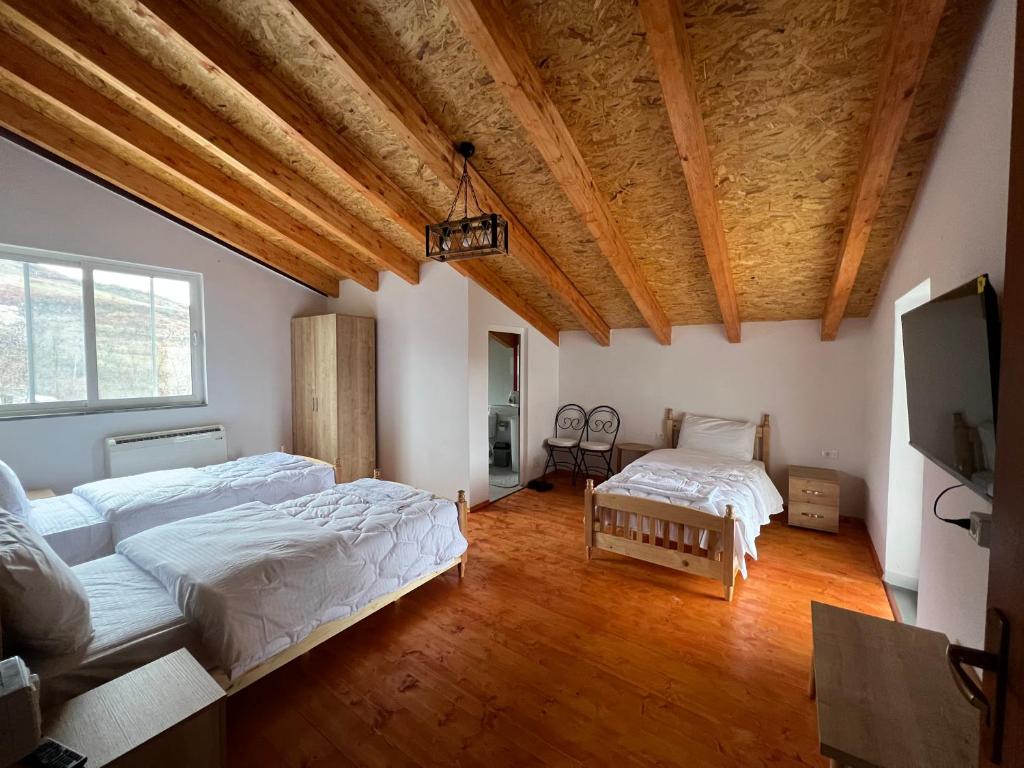 um quarto com 2 camas e uma televisão de ecrã plano em Xhaferri Guesthouse em Zhaban