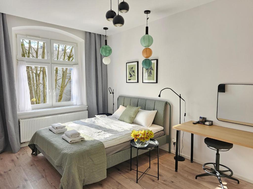 een kleine slaapkamer met een bed en een bureau bij URBAN APARTMENTS PREMIUM No 12A Chorzów, Katowice with PRIVATE PARKING in Chorzów