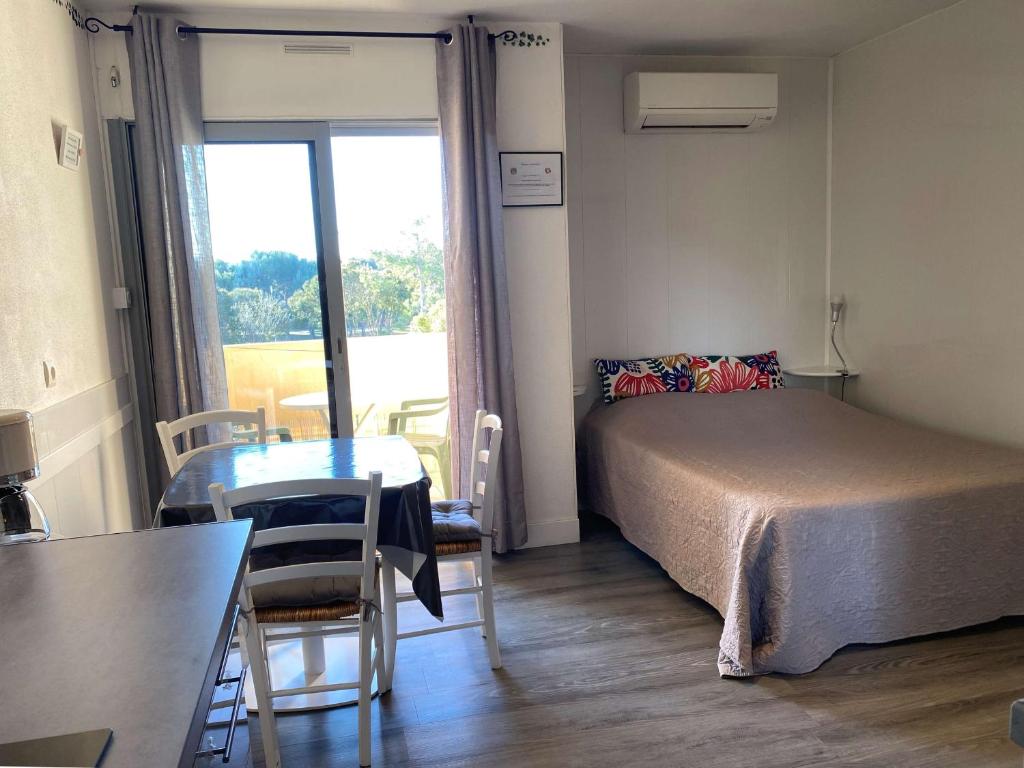une chambre avec un lit, une table et une fenêtre dans l'établissement Studio lumineux avec balcon, wifi, clim, proximité parc - FR-1-553-227, à Balaruc-les-Bains