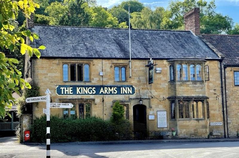 an old brick building with a street sign in front of it at The Kings Arms Inn in Yeovil