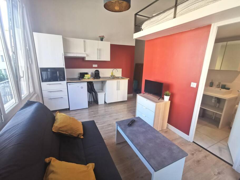 un salon avec un canapé et une cuisine dans l'établissement Lumineux T1 de 23m2 à 100m des Métro/Tram, à Villeurbanne
