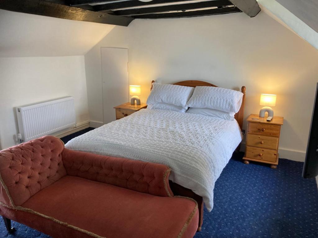 a bedroom with a large bed and a couch at Bryntirion Farmhouse Room with own bathroom in Llanfair Caereinion