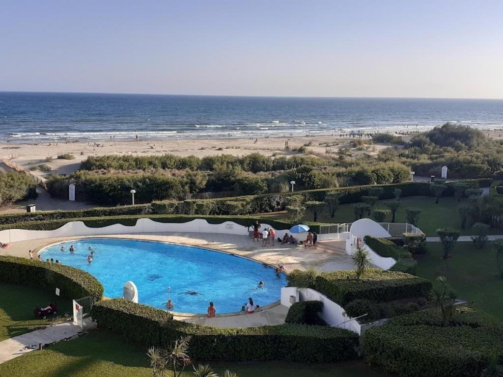 une vue aérienne d'une piscine à côté d'une plage dans l'établissement Studio Cabine avec Terrasse et Piscine à 100m de la Plage à La Grande Motte - FR-1-716-56, à La Grande Motte