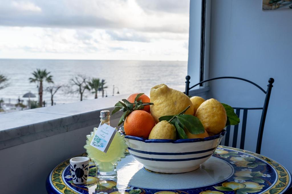 マイオーリにあるMaiori Apartment by Marcelの海の景色を望むテーブルに盛られた果物