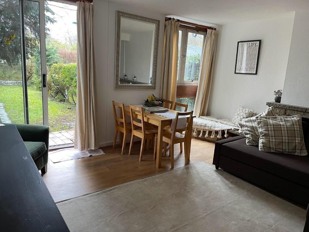 ein Wohnzimmer mit einem Tisch, Stühlen und einem Sofa in der Unterkunft 3 bedroom flat in Maida Vale in London