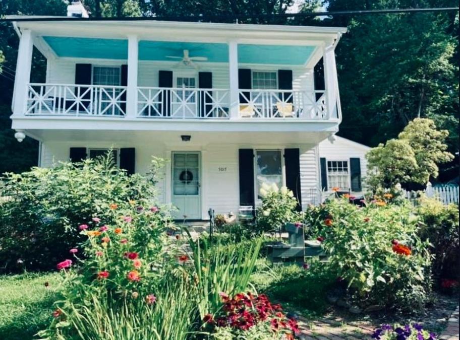 ein weißes Haus mit einem Balkon und Blumen in der Unterkunft House on the Gwynns Falls in Baltimore