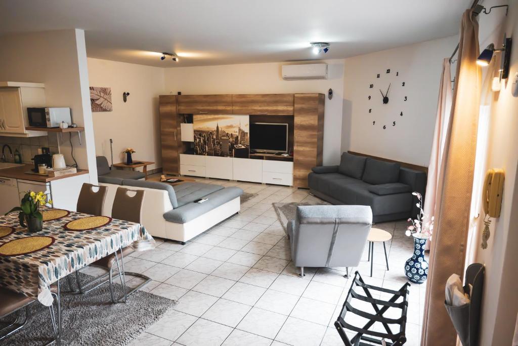 uma sala de estar com um sofá e uma mesa em Bory Apartman, zárt udvari parkolás em Székesfehérvár
