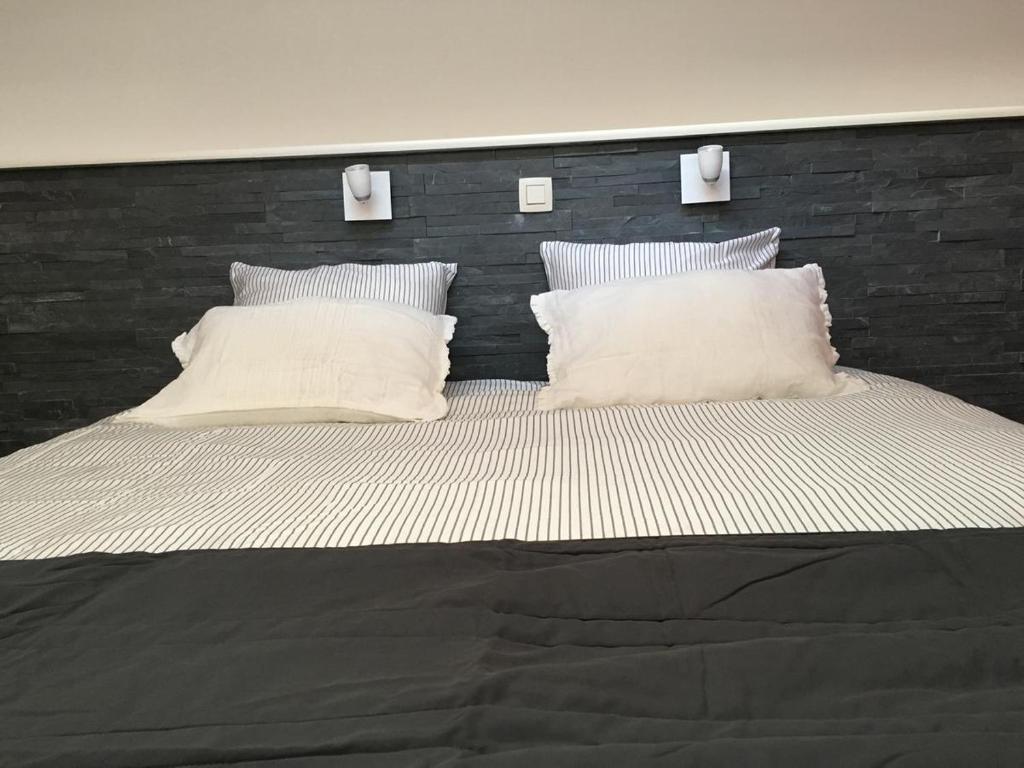 a large bed with two white pillows on it at B&B De Kaai in Nieuwpoort