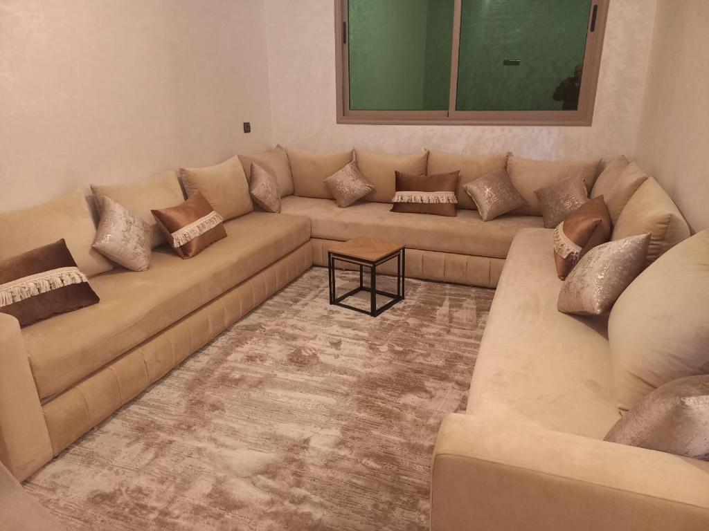 a living room with two couches and a table at Appartement Marjana in Meknès