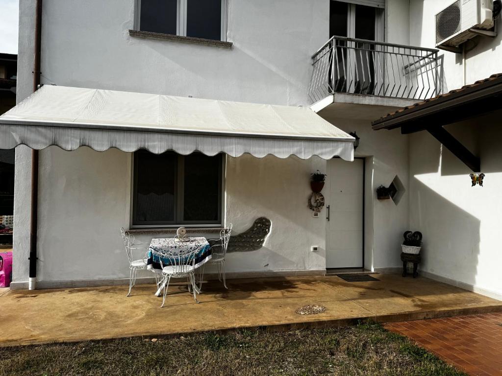 eine Terrasse mit einem Tisch und Stühlen unter Markise in der Unterkunft Beauty and Beast in Ponzano Veneto