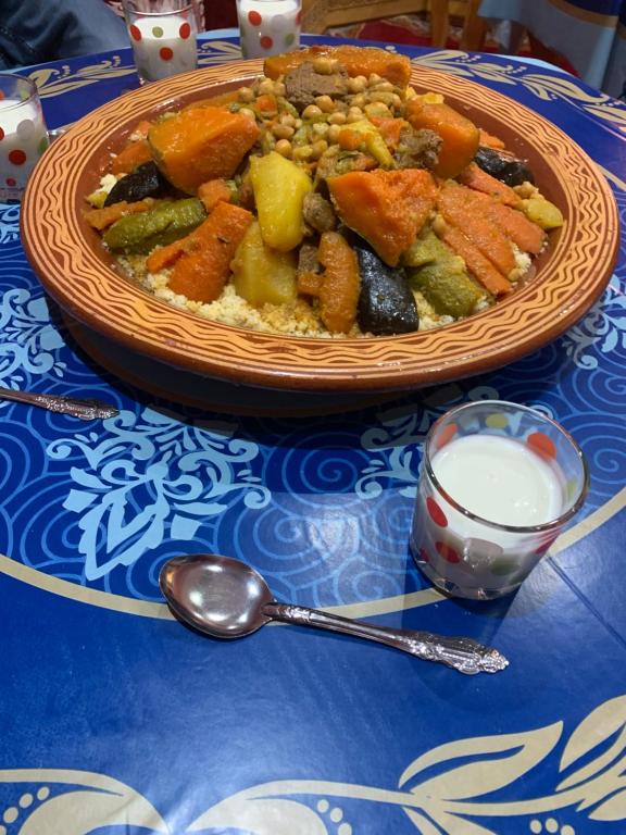 un bol de nourriture sur une table avec une cuillère dans l'établissement Dar Dyafa, 