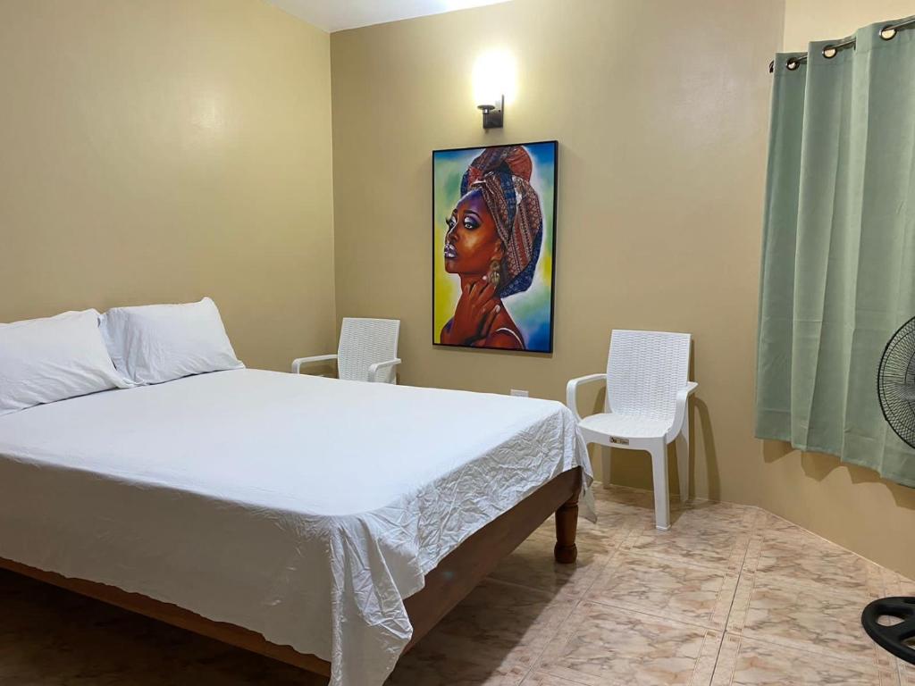 a bedroom with a bed and a painting on the wall at Marshan villa in Montego Bay