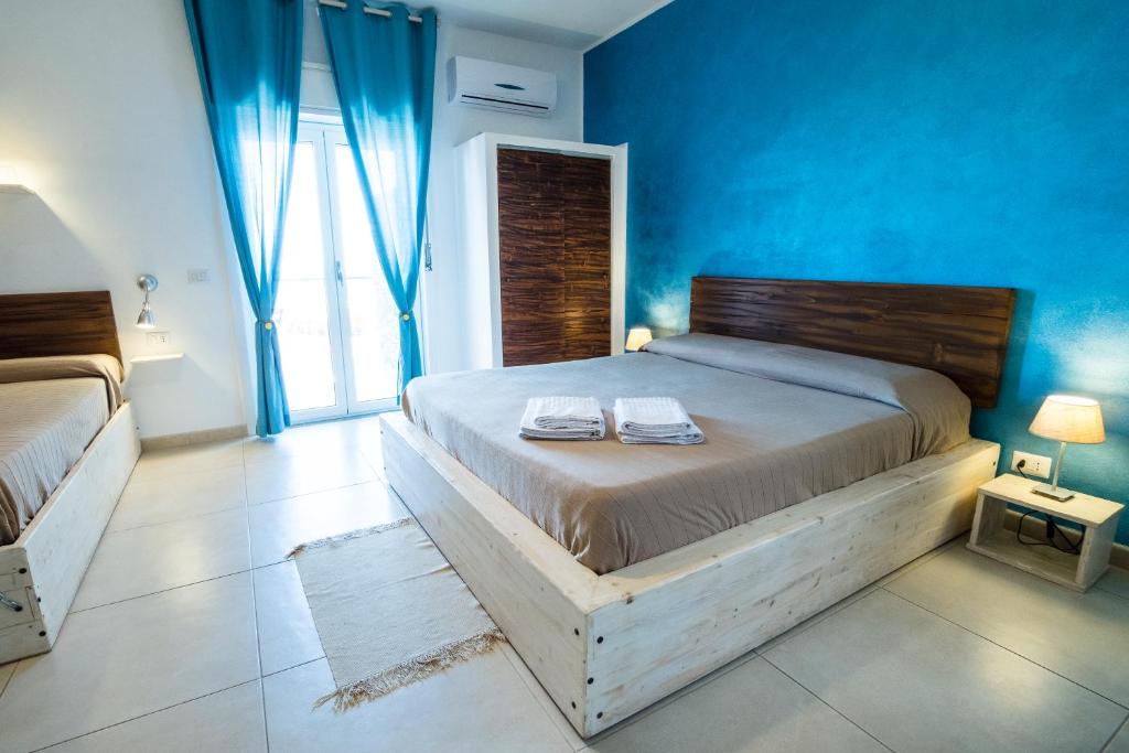 1 dormitorio con 1 cama grande y paredes azules en Casadada, en Santo Stefano di Camastra