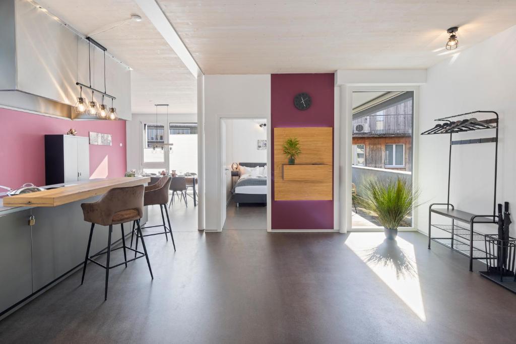 - une cuisine et une salle à manger aux murs roses et violets dans l'établissement Casa Milla, Apartment Langenthal, à Langenthal