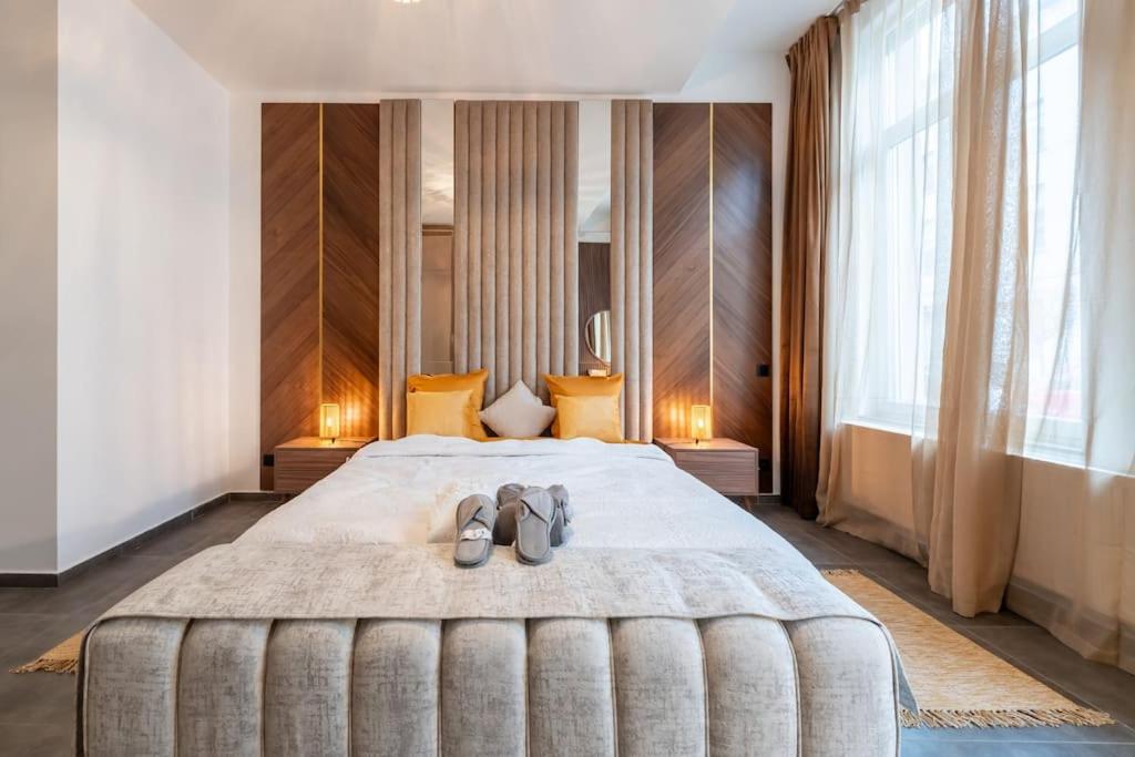 Un dormitorio con una cama grande con dos zapatos. en luxueux appartement 5 chambre en Bruselas