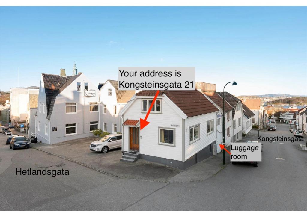 a small white house with a roof on a street at Central Economic Stavanger Kongsteinsgata in Stavanger