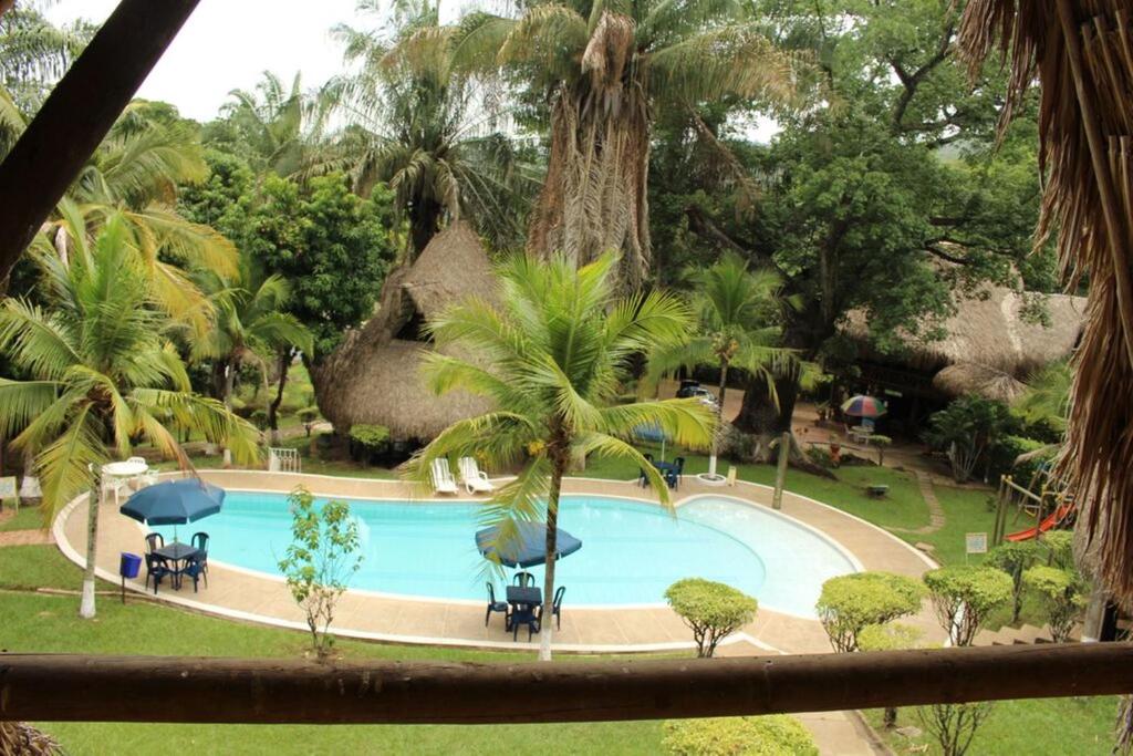 uma piscina em um resort com palmeiras em Eco Hotel El Reposo em Melgar