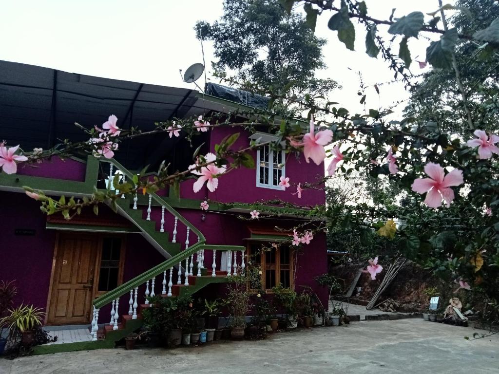 ein lila Haus mit rosa Blumen drauf in der Unterkunft soms estate stay in Madikeri