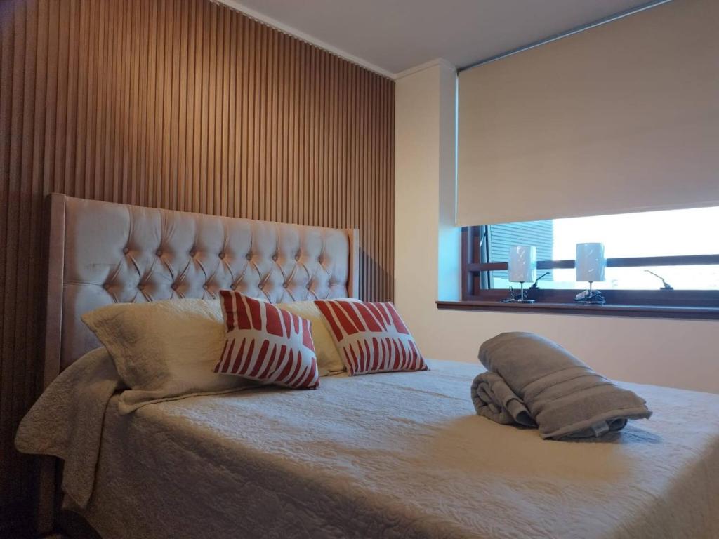 a bedroom with a bed with two pillows on it at Exclusive Apt Parque San Damian in Santiago