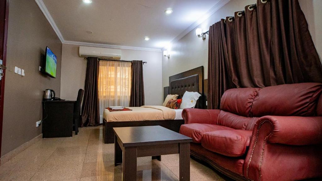 ラゴスにあるKABACHI STACKのソファとベッド付きのホテルルーム
