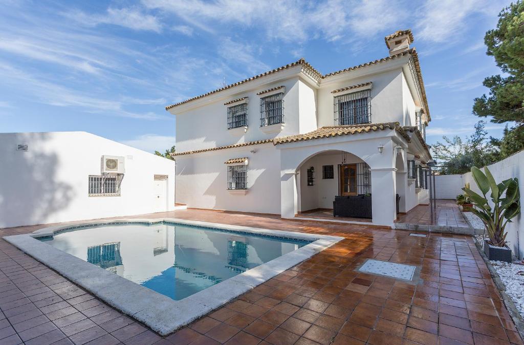 uma casa branca com uma piscina em frente em Azvalia Valdeazahares em El Puerto de Santa María