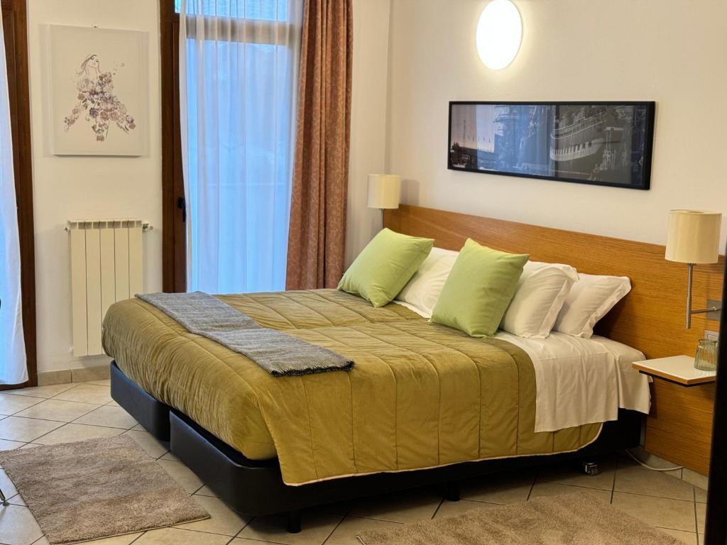 a bedroom with a large bed with green pillows at Residence Malpensa in Somma Lombardo