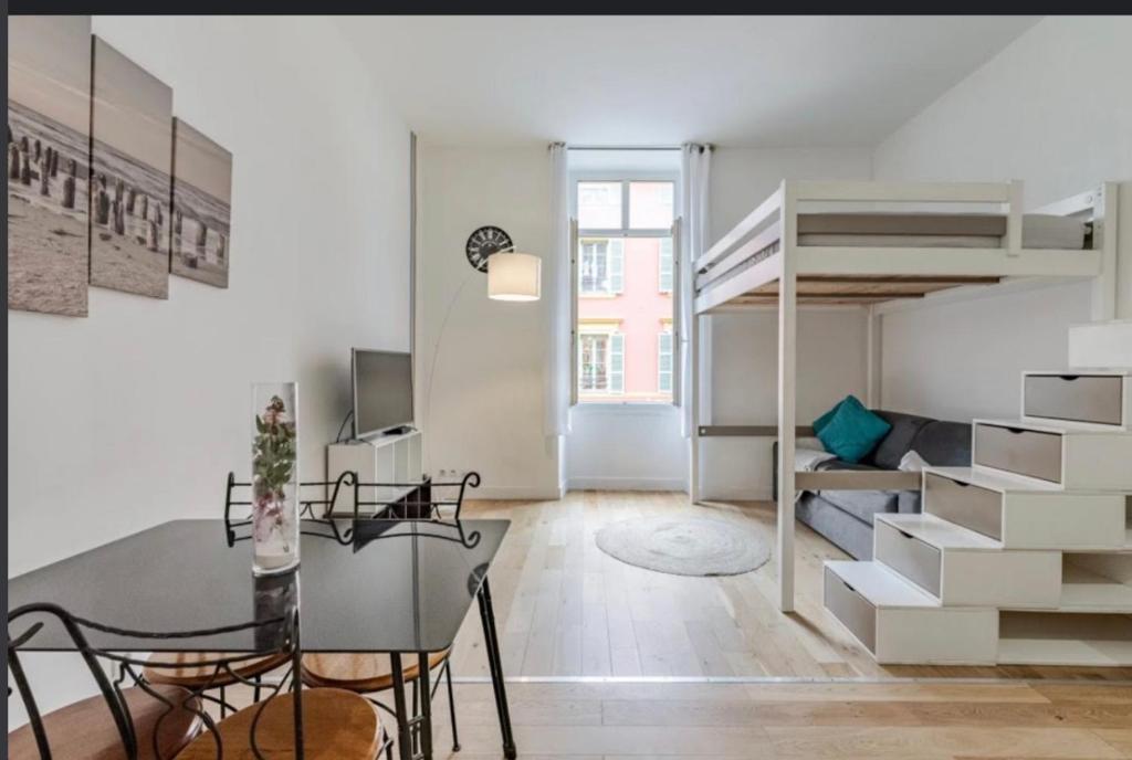 um quarto com uma mesa de jantar e uma cama alta em Jean em Nice