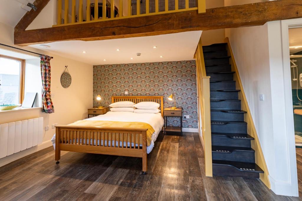 a bedroom with a bed and a staircase at Captains Lookout (Studio apartment) in Brecon
