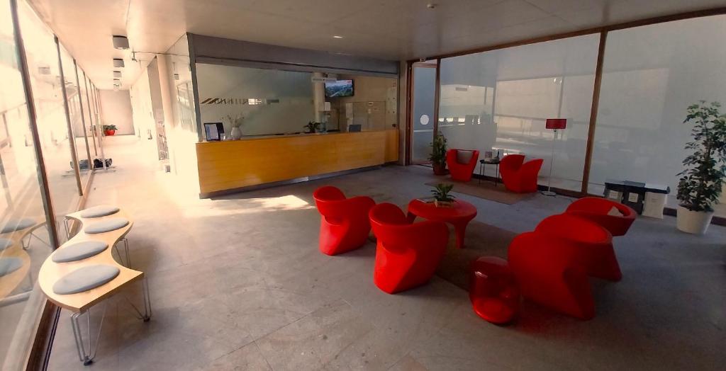 a large room with red chairs and tables in a building at HI Ponte de Lima - Pousada de Juventude in Ponte de Lima