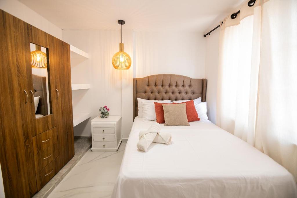 a bedroom with a bed with white sheets and a window at hospedaje rosa blanca in Cartagena de Indias