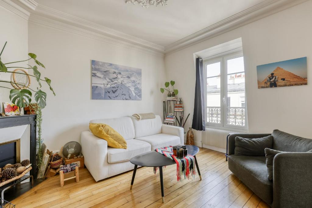 un salon avec un canapé blanc et une cheminée dans l'établissement Stunning & warm flat in the 11th - Parmentier, à Paris