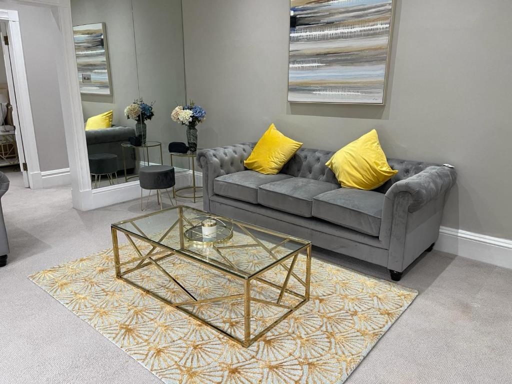 een woonkamer met een bank en een glazen tafel bij Upper Berkely Suits Falcon Group in Londen