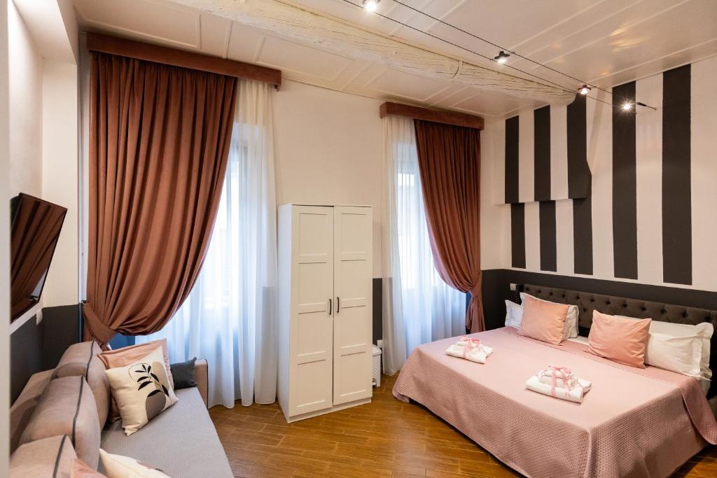 a bedroom with two beds and a couch at Santa Croce Dream Suites in Florence